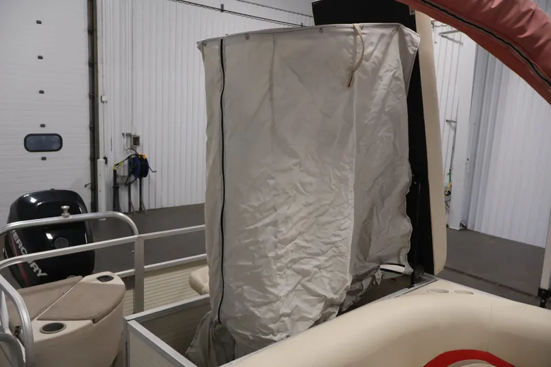 Slide: The Image of 2008 Sun Tracker Fishin' Barge 21 with privacy curtain in indoor storage. - 29