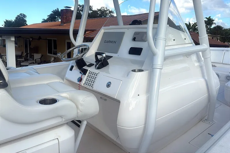 Slide: The Image of 2015 Intrepid 327 Center Console boat helm with Garmin navigation system and white seating. - 13