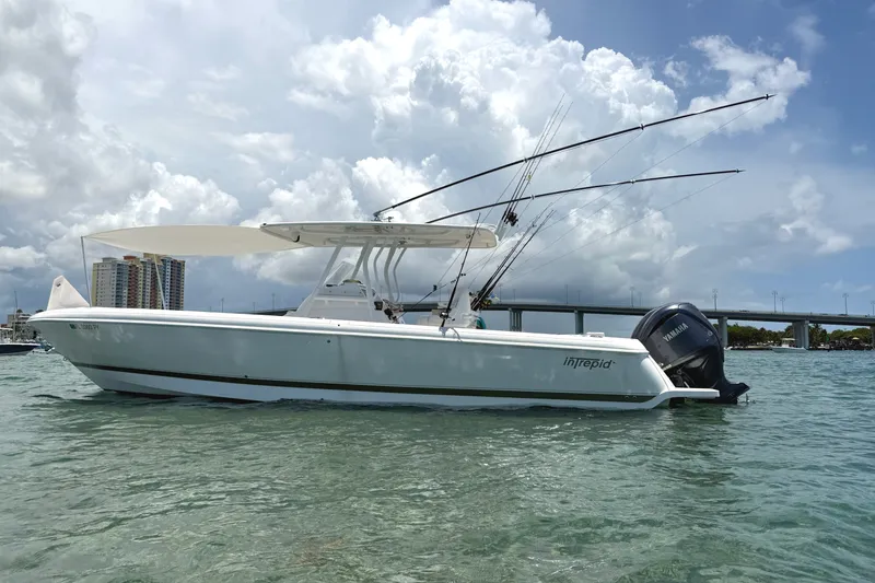 Slide: The Image of 2015 Intrepid 327 Center Console boat on water, under cloudy sky. - 1