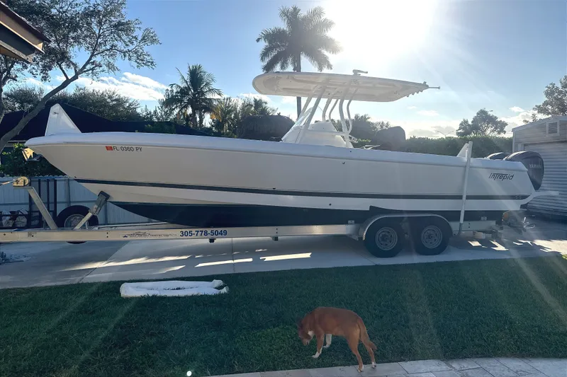 Slide: The Image of 2015 Intrepid 327 Center Console boat on trailer, sunny day, palm trees in background. - 5
