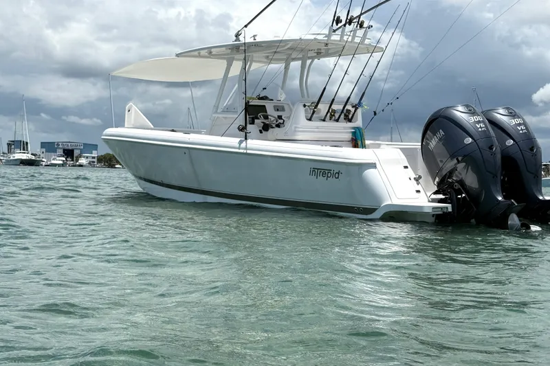 Slide: The Image of 2015 Intrepid 327 Center Console boat with twin Yamaha engines on clear water. - 2