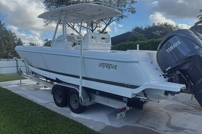 Slide: The Image of 2015 Intrepid 327 Center Console boat on trailer with Yamaha engine, parked outdoors. - 7