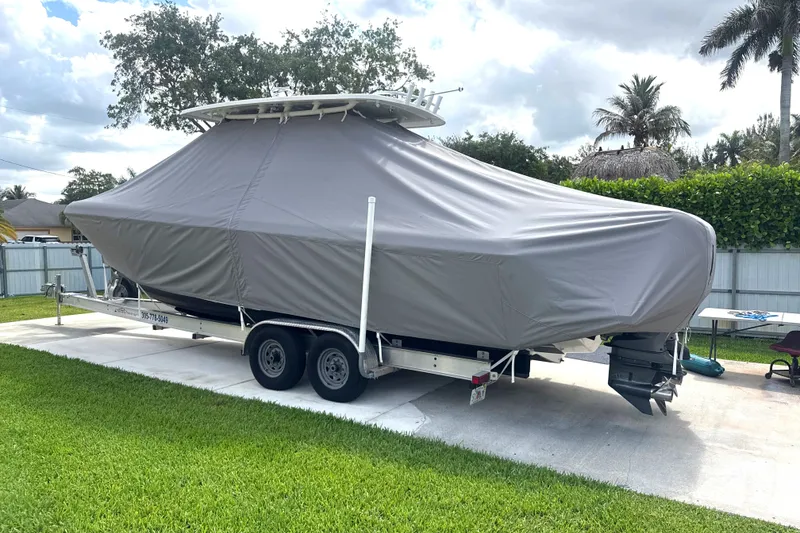Slide: The Image of Covered 2015 Intrepid 327 Center Console boat on trailer in a driveway. - 9