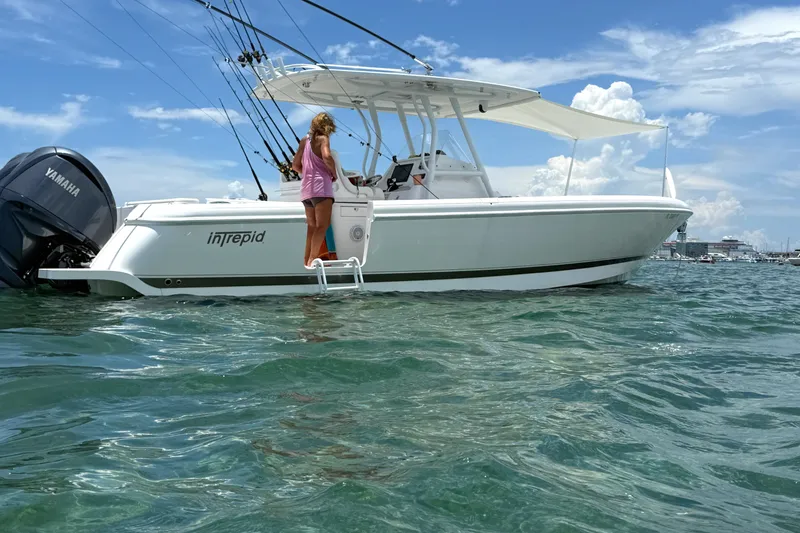 Slide: The Image of 2015 Intrepid 327 Center Console boat on water with person aboard, clear sky background. - 4