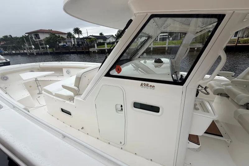 Slide: The Image of 2016 Everglades 435 Center Console boat docked by waterfront homes. - 28