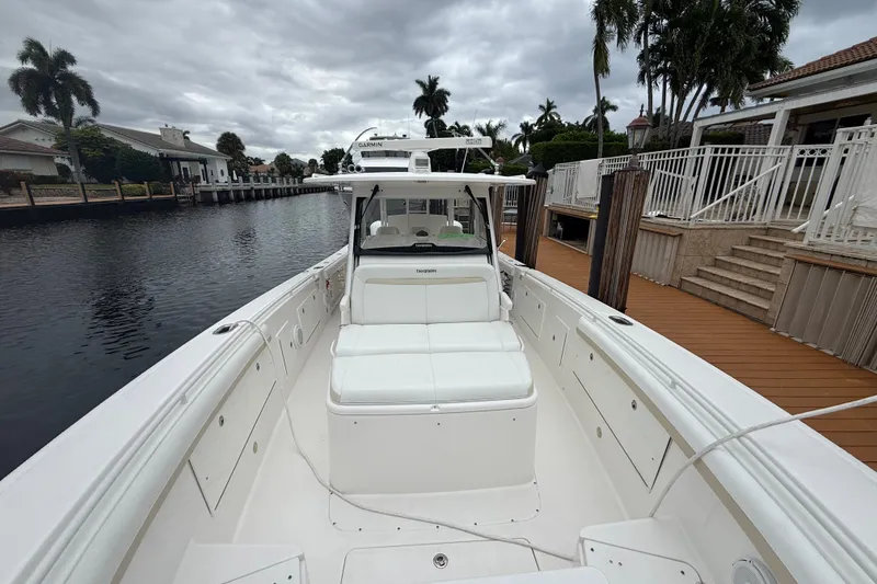 Slide: The Image of 2016 Everglades 435 Center Console boat docked by waterfront homes under cloudy skies. - 17