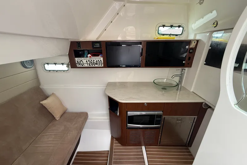 Slide: The Image of Interior of 2016 Everglades 435 Center Console with kitchenette and seating area. - 31