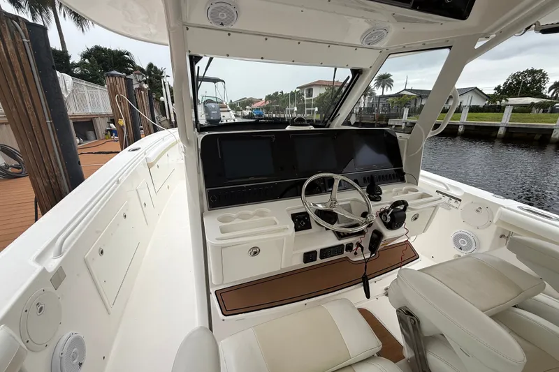 Slide: The Image of 2016 Everglades 435 Center Console boat interior with steering wheel and navigation screens. - 22