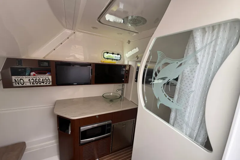 Slide: The Image of Interior of 2016 Everglades 435 Center Console with kitchenette and decorative glass partition. - 32