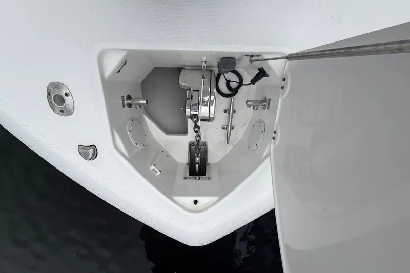 Slide: The Image of Anchor compartment of 2016 Everglades 435 Center Console boat, featuring winch and chain. - 16