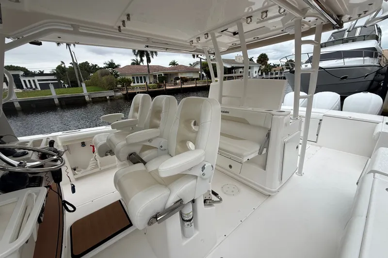 Slide: The Image of 2016 Everglades 435 Center Console boat interior with white seating and helm station. - 21