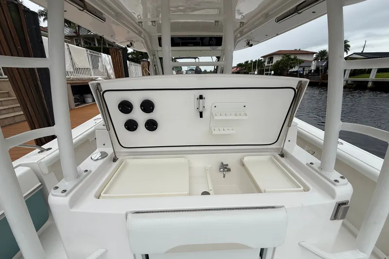 Slide: The Image of 2016 Everglades 435 Center Console boat interior with open storage compartment and sink. - 14