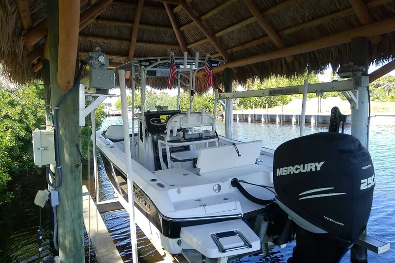 Slide: The Image of 2015 Crevalle 24 Bay boat with Mercury engine under a thatched roof dock. - 5