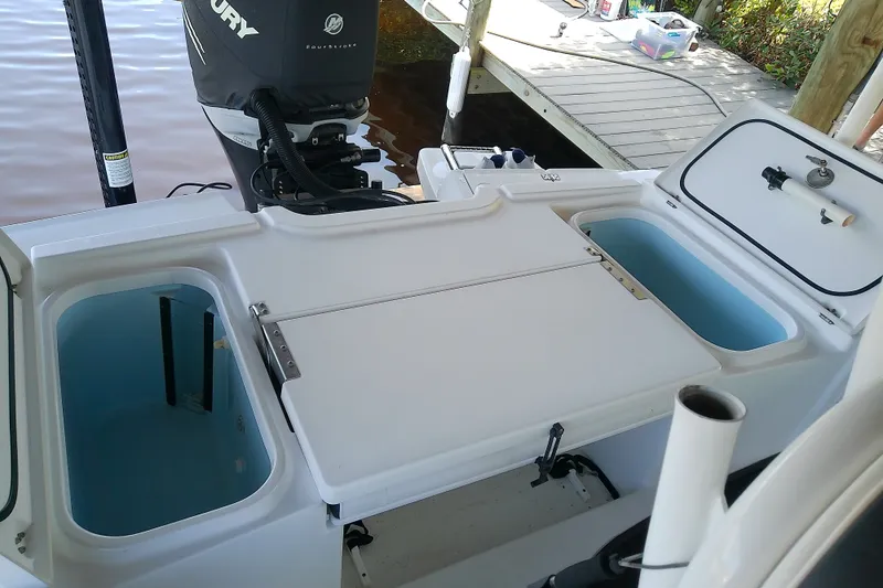 Slide: The Image of 2015 Crevalle 24 Bay boat with Mercury engine, featuring open storage compartments. - 16