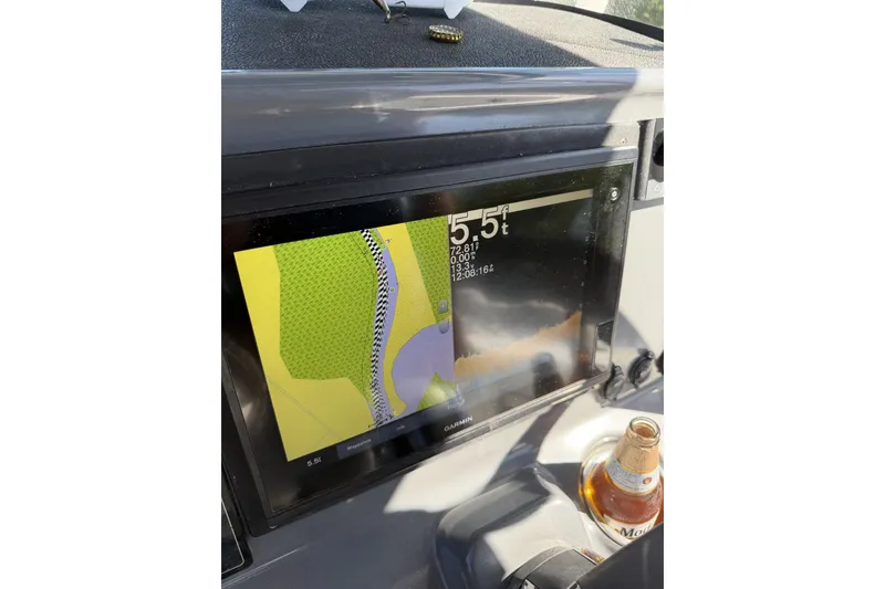 Slide: The Image of Garmin navigation display on 2015 Crevalle 24 Bay boat dashboard with beverage bottle nearby. - 23