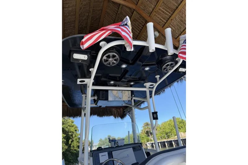 Slide: The Image of 2015 Crevalle 24 Bay boat with American flags under a thatched roof. - 50