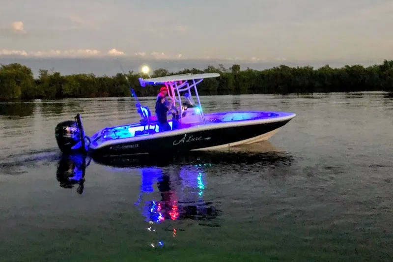 Slide: The Image of 2015 Crevalle 24 Bay boat illuminated on calm water at dusk. - 48