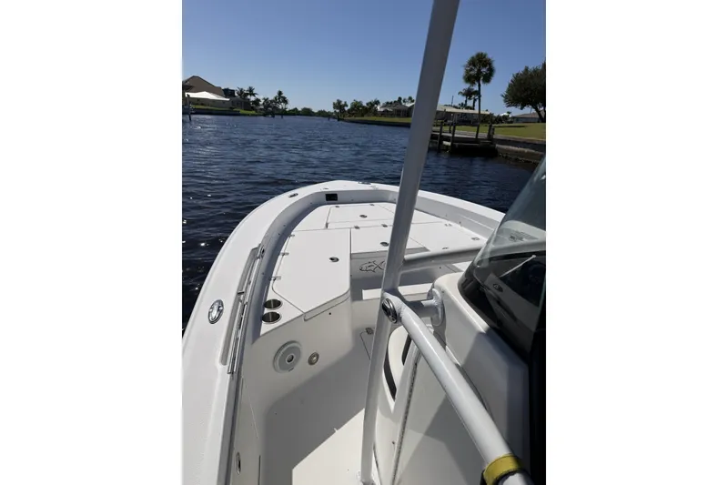 Slide: The Image of 2015 Crevalle 24 Bay boat on a sunny waterfront, showcasing deck and railing. - 40