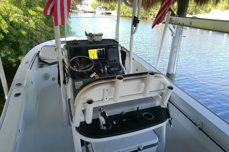Slide: The Image of 2015 Crevalle 24 Bay boat interior with steering console and American flags. - 19