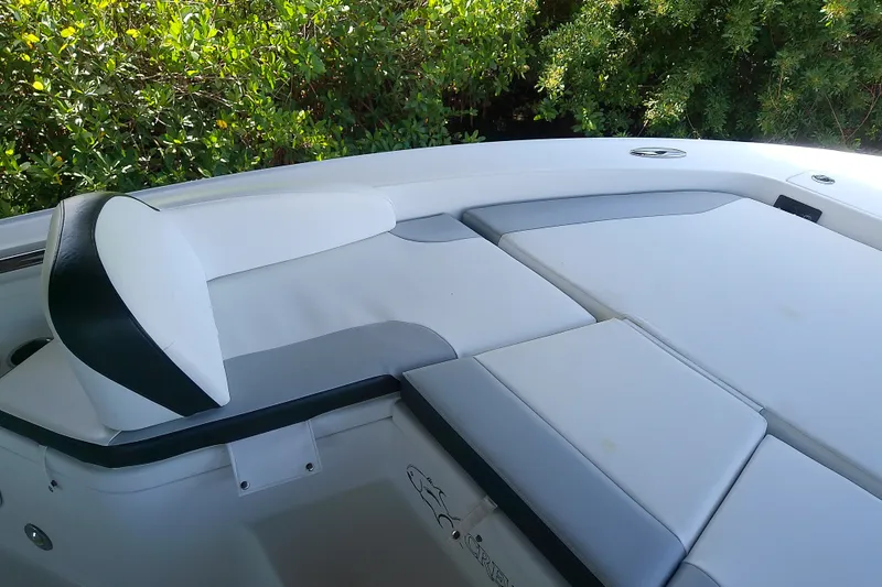 Slide: The Image of 2015 Crevalle 24 Bay boat interior with cushioned seating and greenery background. - 31
