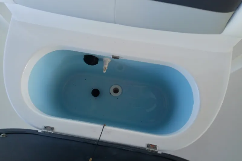 Slide: The Image of Livewell compartment in a 2015 Crevalle 24 Bay boat, featuring a blue interior. - 33