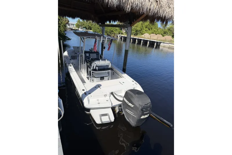 Slide: The Image of 2015 Crevalle 24 Bay boat docked with Mercury 250 engine, under a thatched roof. - 45