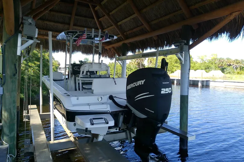 Slide: The Image of 2015 Crevalle 24 Bay boat with Mercury 250 engine under a thatched roof dock. - 8
