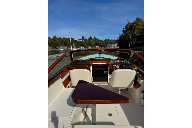 Slide: The Image of 2007 Hinckley Talaria 29R boat interior with wooden accents and scenic waterway view. - 16
