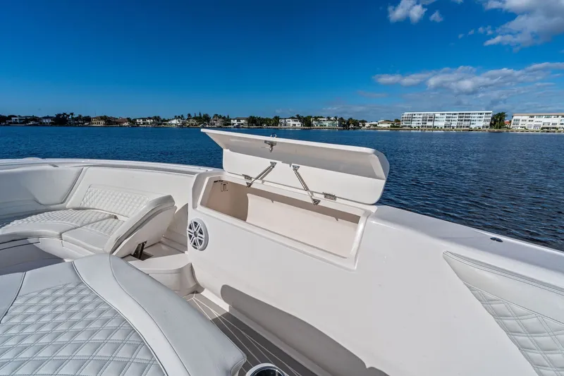 Slide: The Image of 2022 Intrepid 407 Nomad FE boat interior with open storage compartment, on calm water. - 19