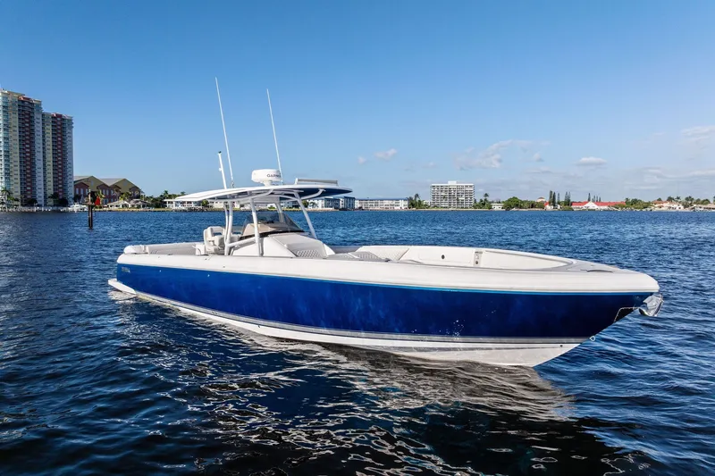 Slide: The Image of 2022 Intrepid 407 Nomad FE boat on calm water, cityscape background. - 7
