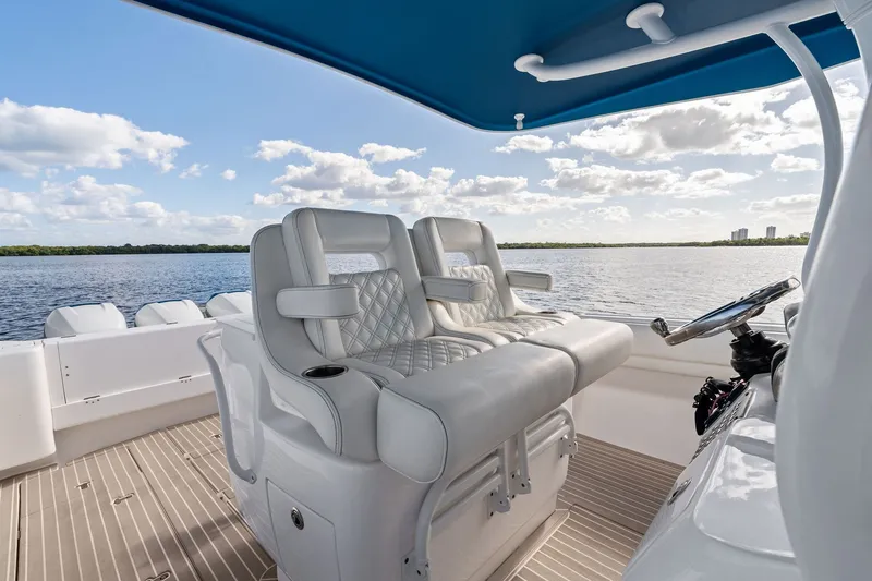 Slide: The Image of 2022 Intrepid 407 Nomad FE boat interior with luxurious seating and scenic water view. - 24