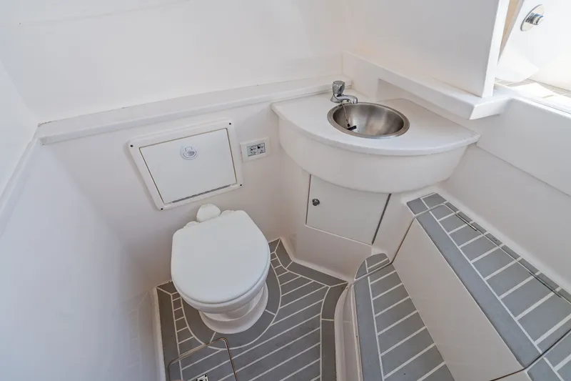Slide: The Image of 2022 Intrepid 407 Nomad FE boat bathroom with toilet, sink, and seating area. - 27