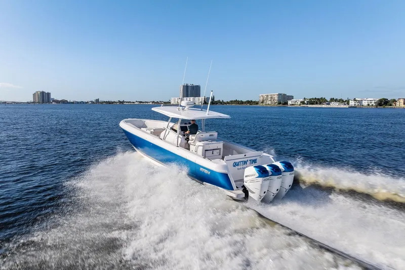 Slide: The Image of 2022 Intrepid 407 Nomad FE boat cruising on open water, cityscape in background. - 4