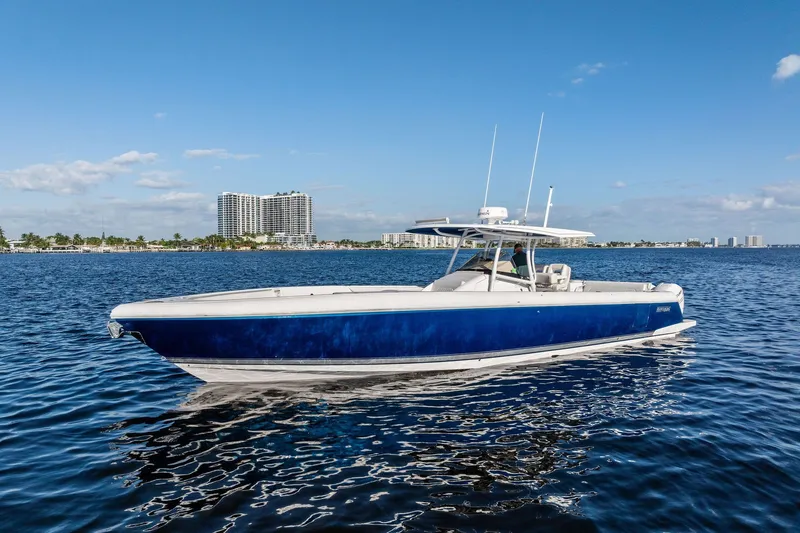 Slide: The Image of 2022 Intrepid 407 Nomad FE boat on calm water with city skyline background. - 8