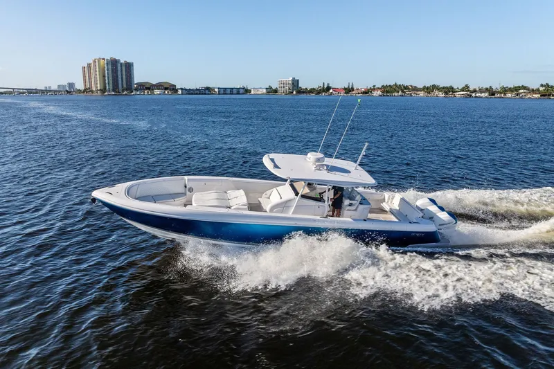 Slide: The Image of 2022 Intrepid 407 Nomad FE cruising on open water, cityscape in background. - 2