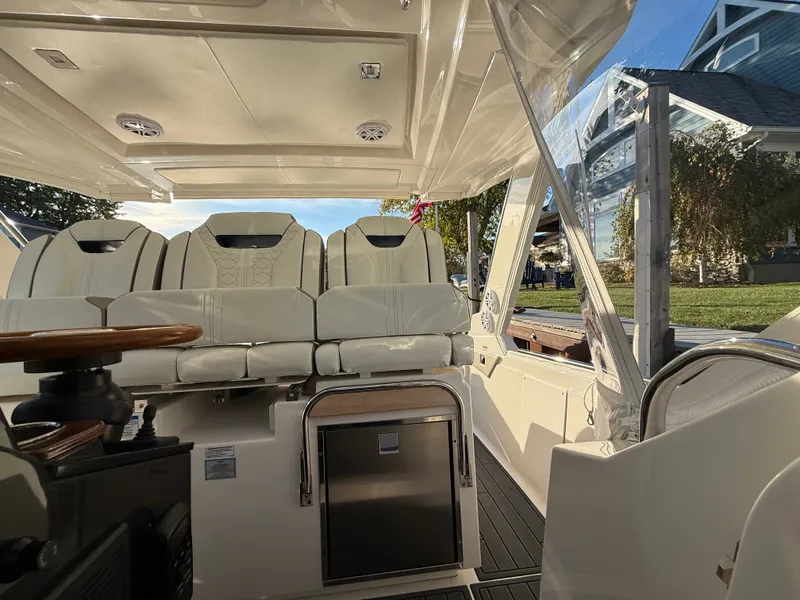 Slide: The Image of The image shows the luxurious cockpit of a 2025 Tiara Yachts 34 LS with elegant white seating and a modern helm. - 27