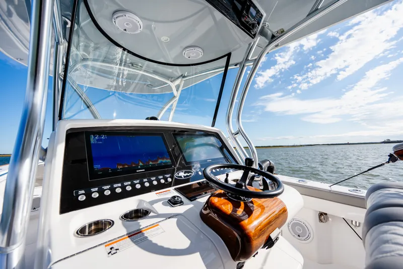 Slide: The Image of Valhalla V-33 2025 boat dashboard with navigation screens and steering wheel on open water. - 25