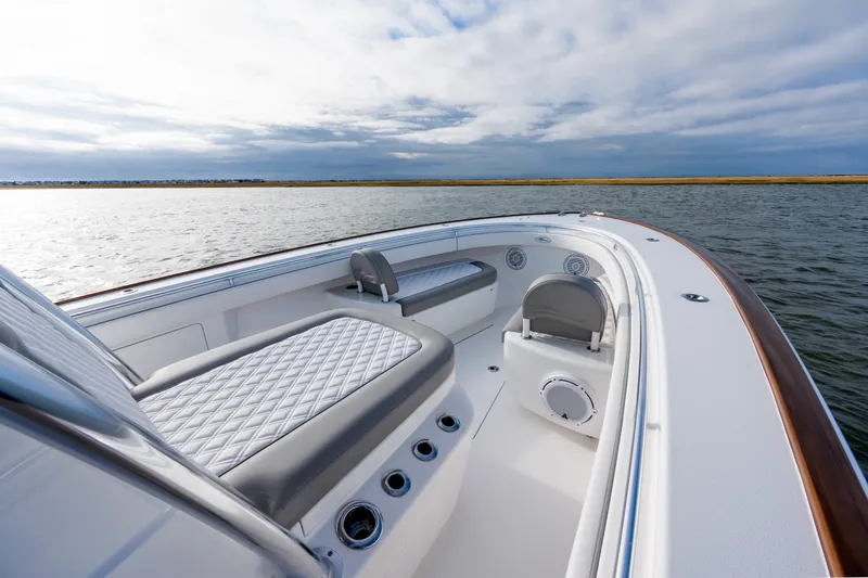 Slide: The Image of Valhalla V-33 2025 boat interior with cushioned seating on calm water. - 11