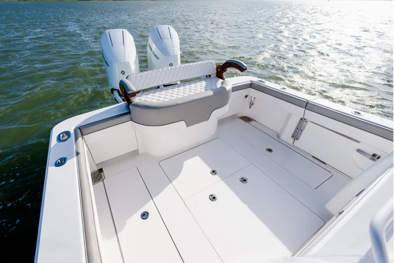 Slide: The Image of Sleek 2025 Valhalla V-33 boat deck with dual engines on calm water. - 28