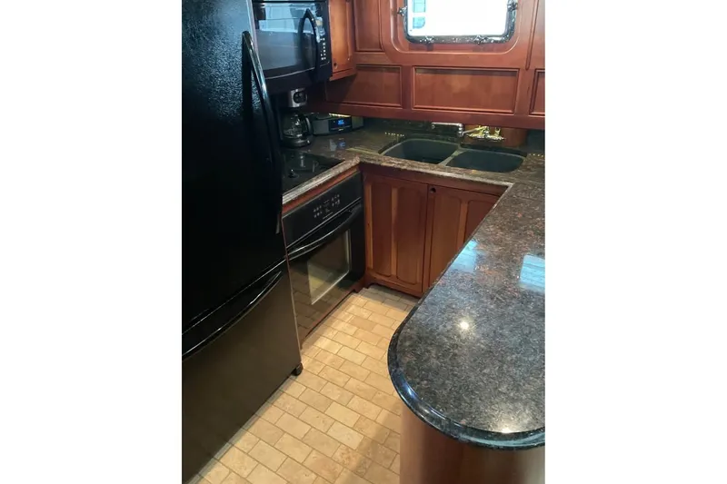 Slide: The Image of Kitchen interior of 2009 Custom Thomas 50 Dutch Barge with granite countertops and wooden cabinetry. - 3