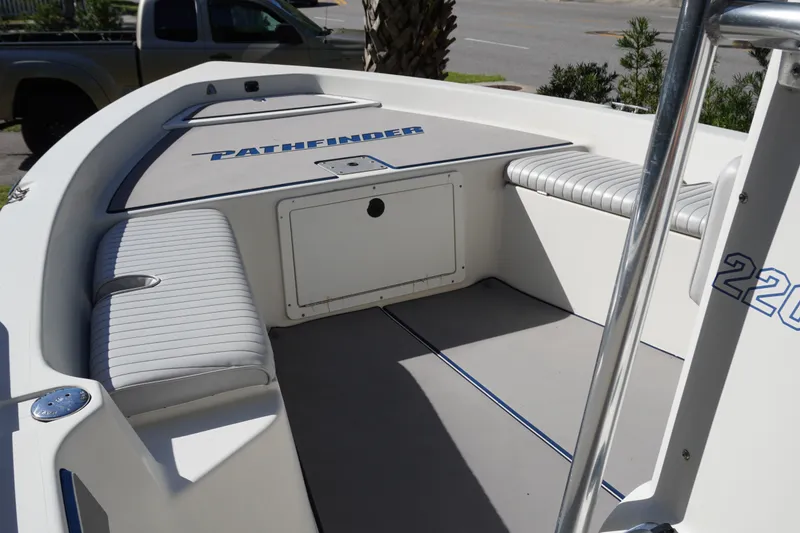 Slide: The Image of 2000 Pathfinder 2200 V boat interior with cushioned seating and storage compartment. - 13