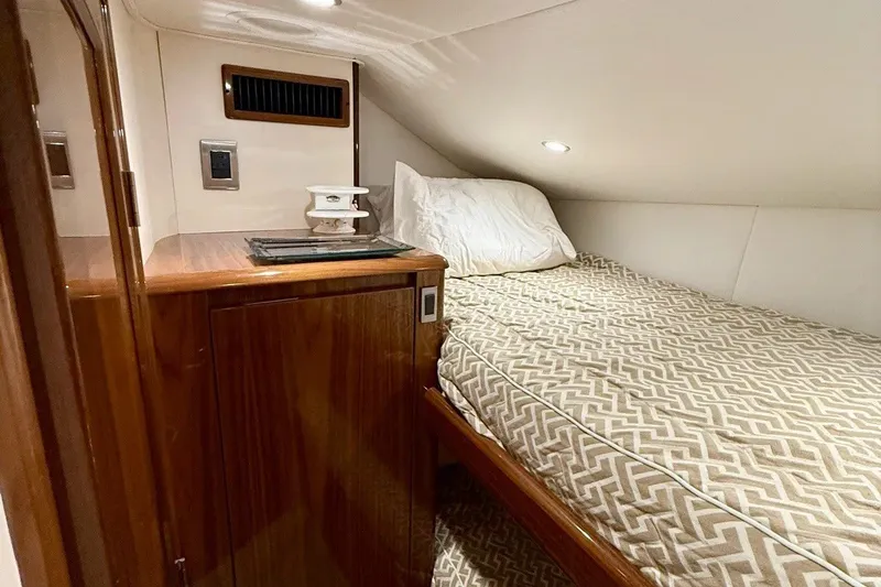 Slide: The Image of Cozy cabin interior of 2018 Viking 52 Convertible yacht with patterned bedding. - 15