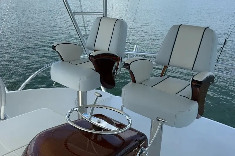 Slide: The Image of Luxury helm chairs on 2018 Viking 52 Convertible yacht, overlooking calm ocean waters. - 30