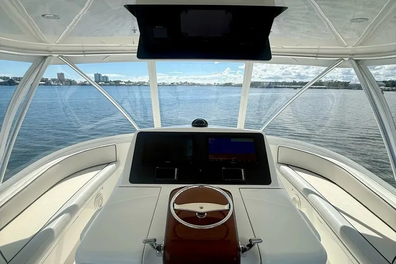 Slide: The Image of Helm view of 2018 Viking 52 Convertible yacht on calm waters. - 27