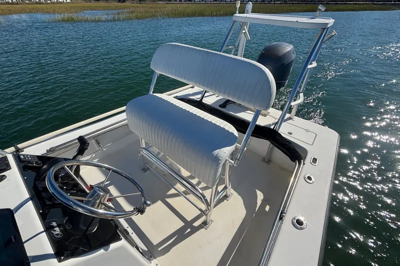 Slide: The Image of 2008 Intruder 198 boat interior with steering wheel and seating on calm water. - 14