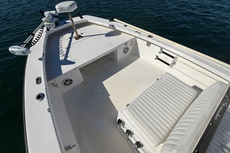 Slide: The Image of 2008 Intruder 198 boat interior with white seating and trolling motor on water. - 12