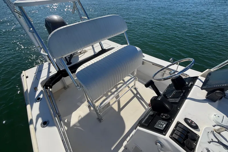 Slide: The Image of 2008 Intruder 198 boat interior with steering wheel and seating, on calm water. - 13