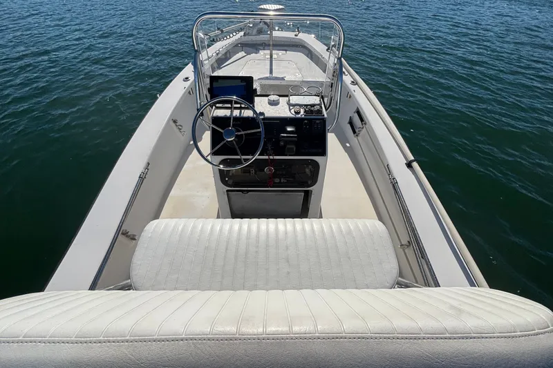 Slide: The Image of 2008 Intruder 198 boat interior with steering wheel and seating, on calm water. - 8