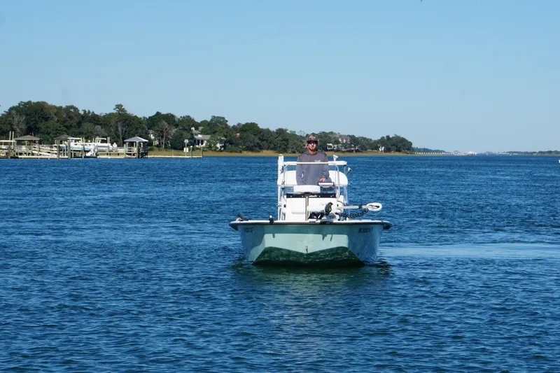 Slide: The Image of A 2008 Intruder 198 boat navigating calm waters near a scenic shoreline. - 6