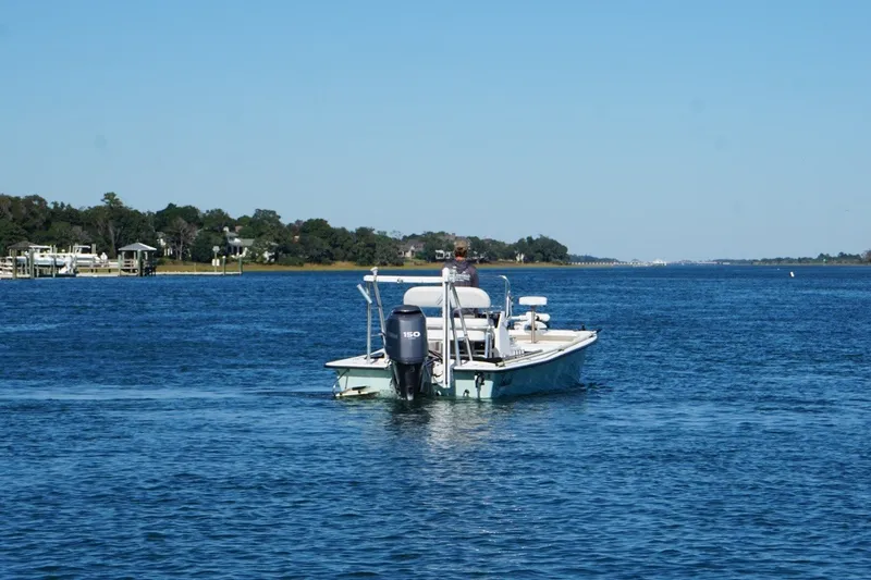 Slide: The Image of A 2008 Intruder 198 boat navigating a calm blue waterway under a clear sky. - 3